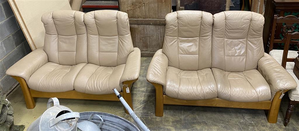 A pair of Norwegian Ekornes Stressless reclining two-seat settees with leather upholstery, length 150cm, depth 78cm, height 104cm